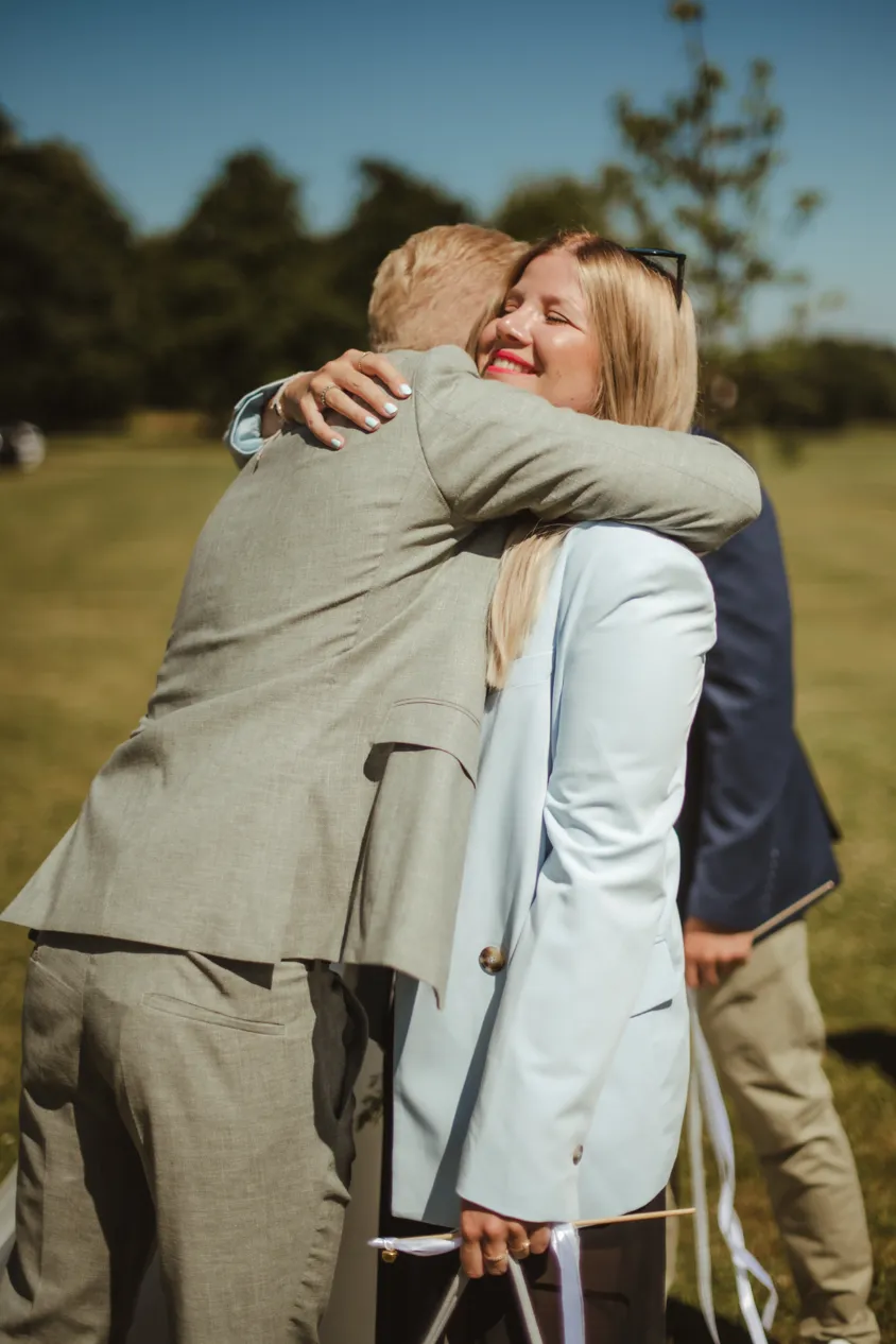 Groom hugging guests in congratulation outdoors