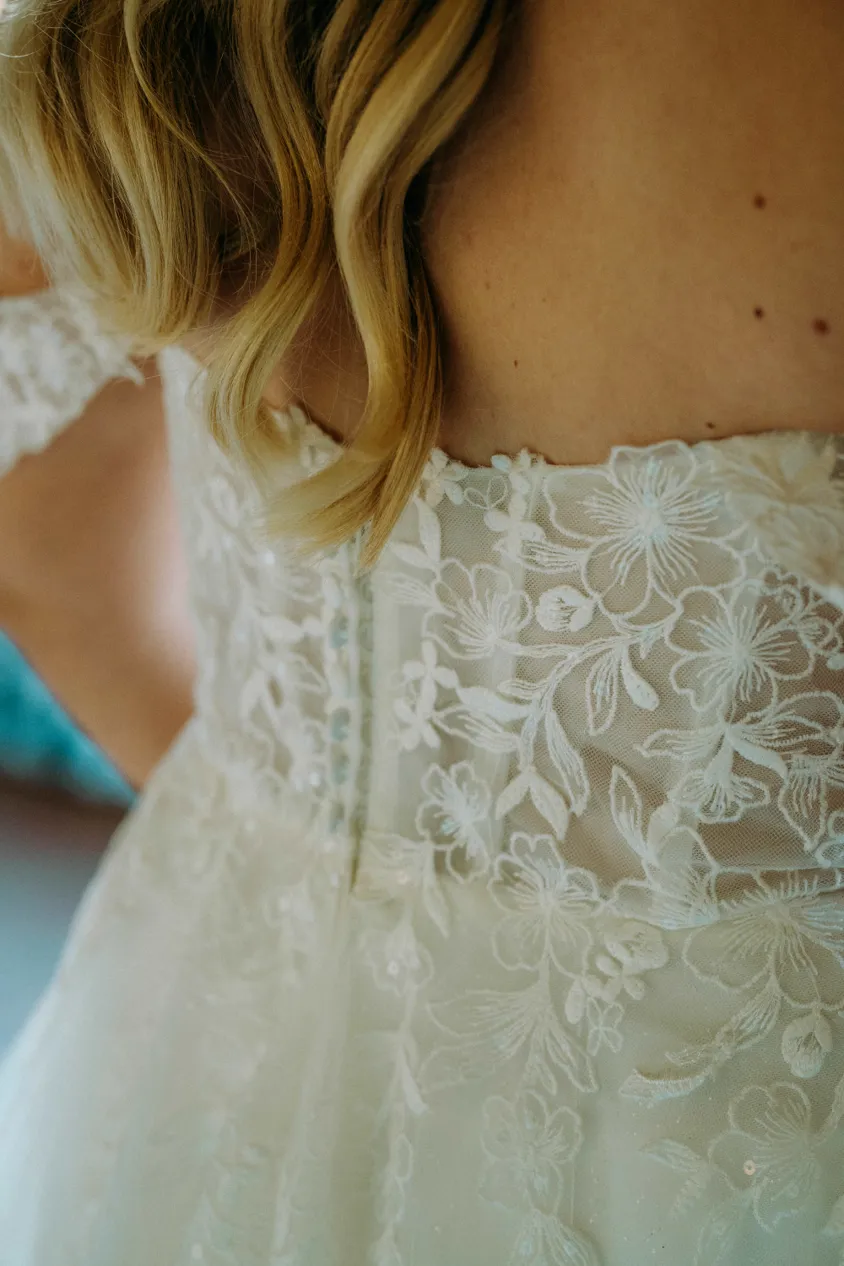 Rücken der Braut mit floraler Spitze am Brautkleid