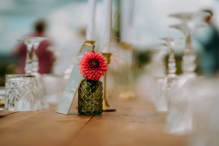 Tischdekoration mit pinker Dahlie in grüner Vase